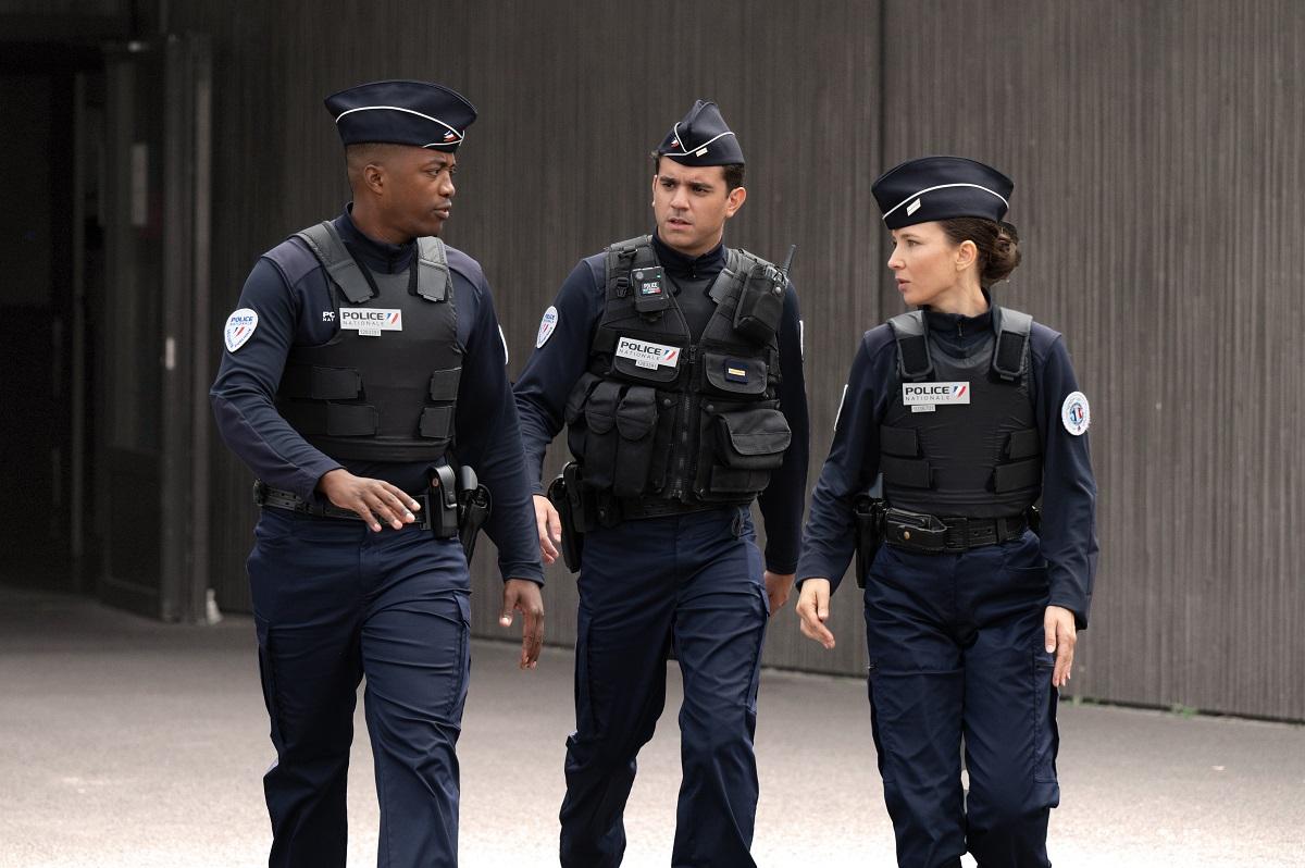 Trois policiers marchant en uniforme et discutant
