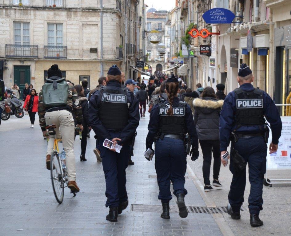policiers patrouillant de dos dans une rue